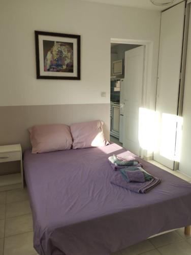 une chambre avec un lit avec des draps violets et deux lampes dans l'établissement Modestie, à Breil-sur-Roya