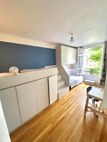 une pièce avec une chambre avec un lit et un bureau dans l'établissement Grand appartement dans Paris 8 couchages, à Paris