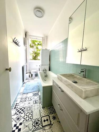une salle de bain avec un lavabo et un miroir dans l'établissement Grand appartement dans Paris 8 couchages, à Paris