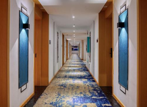 a long hallway with blue and orange walls and a long aisle at Songshe Hotel - Yangshuo West Street in Yangshuo
