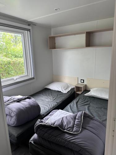 une chambre avec deux lits et une fenêtre dans l'établissement Mobil home XL confort, à Ivry-la-Bataille