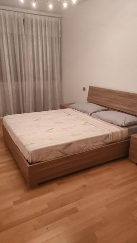 a large bed in a bedroom with a wooden floor at Veronica Apartament in Dosson