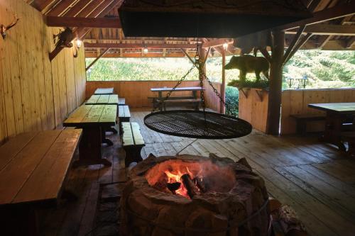 a room with a fire pit and benches and tables at Villa Biesisko Przysłup Cisna in Cisna