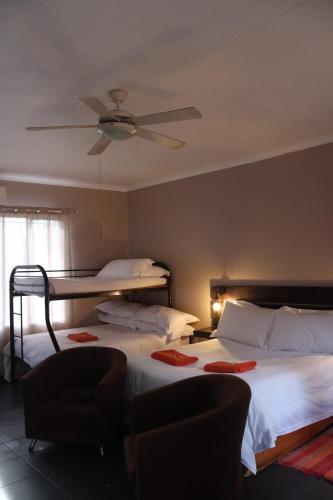 a bedroom with two beds and a ceiling fan at The Ultimate Lodge in Louis Trichardt