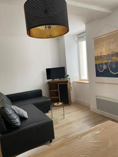 un salon avec un canapé noir et une télévision dans l'établissement Appartement Luz Saint Sauveur / Tourmalet, à Luz-Saint-Sauveur