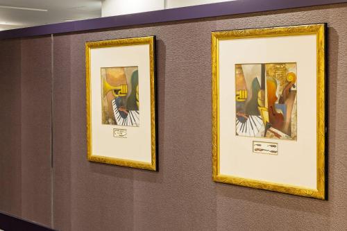 a group of framed pictures on a wall at Hotel Metropolitan Takasaki in Takasaki