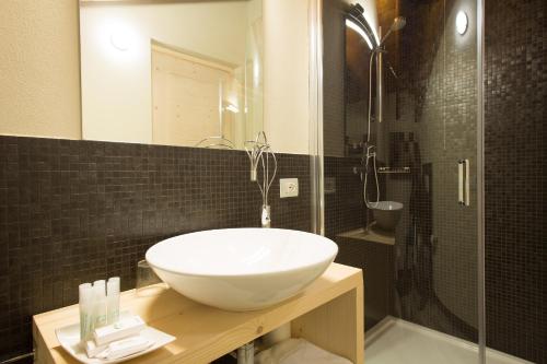 a bathroom with a white sink and a shower at La Burla in Borgosesia
