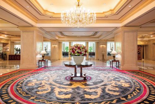 a lobby with a large rug and a vase of flowers at Rihga Royal Hotel Tokyo in Tokyo