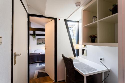 a small room with a desk and a mirror at Dijkstra Hotels in Bergen