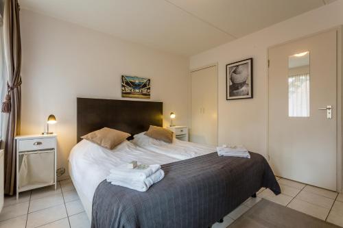 a bedroom with a bed with two towels on it at Dijkstra Hotels in Bergen
