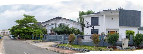 a white house with a fence on a street at LEKKI SECRET MANSION 'n' SWIMMING POOl in Aja