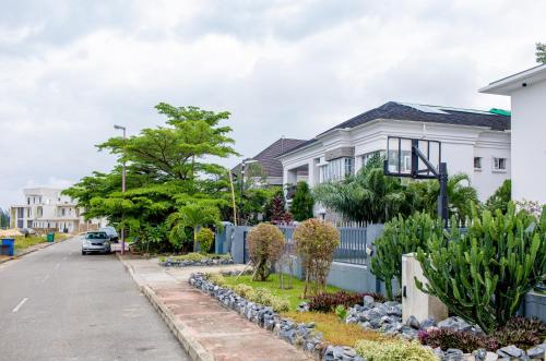 a house with a blue fence in front of a street at LEKKI SECRET MANSION 'n' SWIMMING POOl in Aja