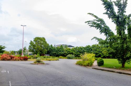 an empty street in a park with trees and bushes at LEKKI SECRET MANSION 'n' SWIMMING POOl in Aja