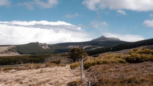 a view of the mountains from the top of a hill at Roulottes - Les lits de berger in Saint-Front