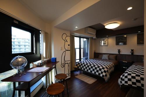 Un dormitorio con una cama y un escritorio y una cama y una habitación. en 島内小宿, en Osaka