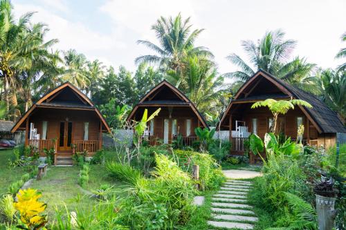 a couple of cottages in a resort with palm trees at Aranka Tempasan in Sangyang