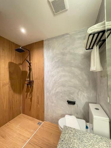 a small bathroom with a toilet and a sink at At Thaphae Hostel in Chiang Mai