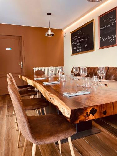 a dining room with a large wooden table with wine glasses at Manoir Belle Fontaine in Noaillan