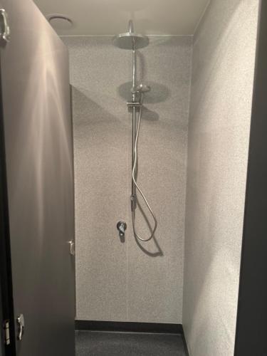 a shower in a bathroom with a glass door at UpTown Backpackers in Dunedin