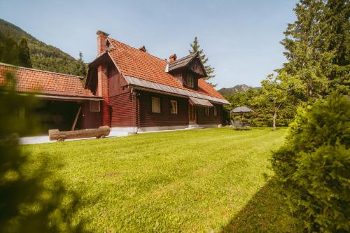 a house with a bench in a yard at Cozy Alpine House in Gozd Martuljek