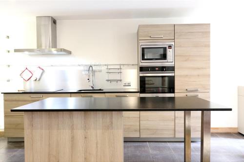 - une cuisine avec un comptoir et un four micro-ondes dans l'établissement Cozy Alpine Stay Séjour cosy au centre, à Chamonix-Mont-Blanc