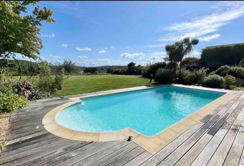 una piscina en una terraza de madera junto a un patio en Villa Roch Ana, en Plouézocʼh