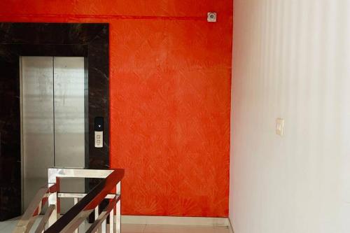 an orange wall in a room with a elevator at Rajamandiram 3BHK AC,Near Sree Padmanabhaswamy Temple, Trivandrum Central in Trivandrum