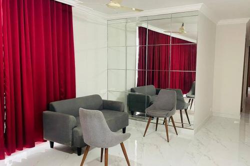 a waiting room with red curtains and chairs at Rajamandiram 3BHK AC,Near Sree Padmanabhaswamy Temple, Trivandrum Central in Trivandrum