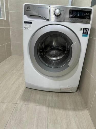 a washing machine is sitting in a bathroom at Capybara House in Kluang