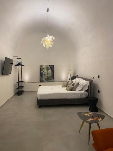 a bedroom with a bed and a chandelier at Marì Luxury House in Noto