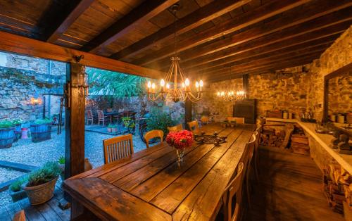 a dining room with a wooden table and a chandelier at La Maison au Puits in Cordes-sur-Ciel