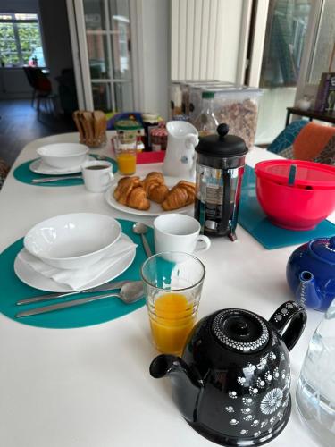 a table with plates and cups and a teapot at Chez Ana in Saxmundham
