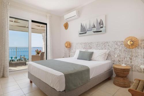 a bedroom with a bed with a view of the ocean at Villa Alemar House with Private pool and Spectacular sea views just 150m to the beach in Barbati