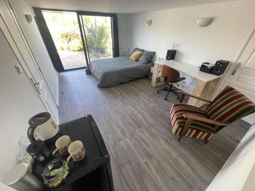 a small living room with a bed and a desk at La matelloise in Les Matelles