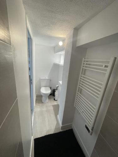 a white bathroom with a toilet and a hallway at La matelloise in Les Matelles