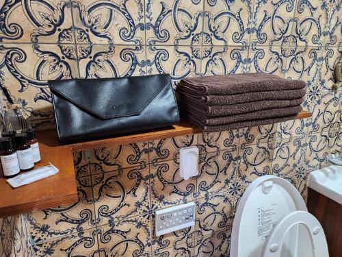a black purse sitting on a shelf above a toilet at Yeongjingil 51 in Gangneung