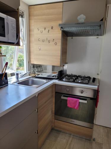 une cuisine avec une cuisinière et un évier dans l'établissement Siblu village, à Valras-Plage