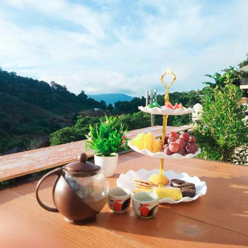 a table with a tray of fruit and a tea set at ม่อนหนาวSpecial room in Mon Jam