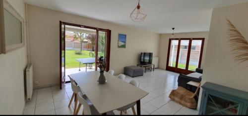 un salon avec une table et une cheminée dans l'établissement Maison familiale Cazaux, à La Teste-de-Buch