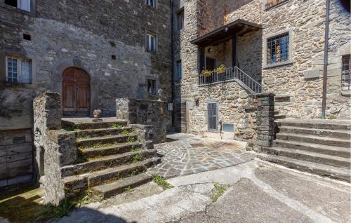 stary kamienny budynek ze schodami i drzwiami w obiekcie Nice Home In Nicciano With Jacuzzi w mieście Piazza al Serchio
