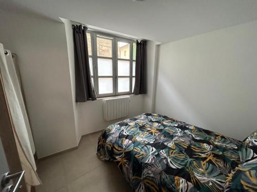 une petite chambre avec un lit et une fenêtre dans l'établissement Joli T2 chez Mumu, à Saint-Donat-sur-lʼHerbasse