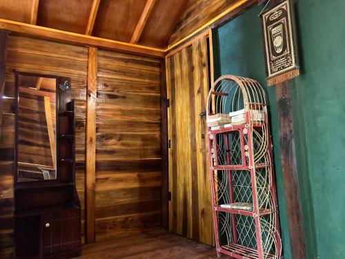 a room with a wooden wall and a pink cage at River Point in Pottuvil