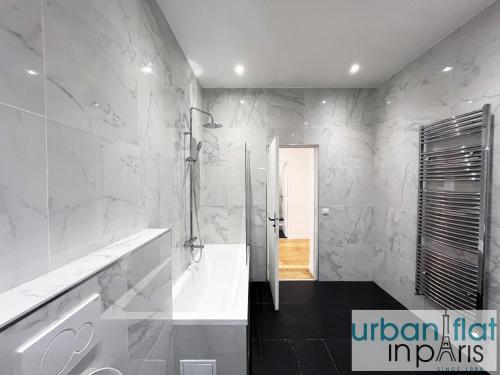 une salle de bain avec une baignoire blanche et une douche dans l'établissement Urban Flat 186 - Spacious 3 Bedroom Flat in Paris, à Paris