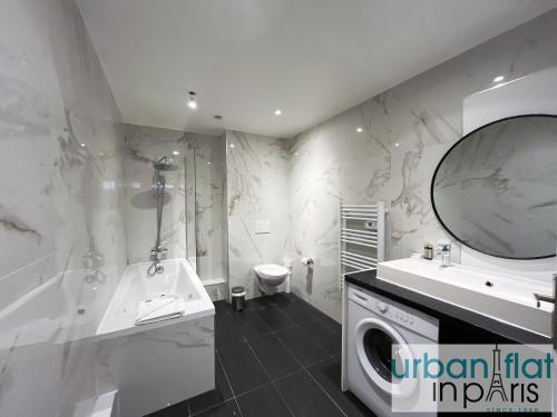 une salle de bain avec une machine à laver, un lavabo et une machine à laver dans l'établissement Urban Flat 185 - Pretty 2 Bedroom Apartment in Paris, à Paris