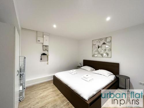- une chambre dotée d'un lit avec des draps blancs dans l'établissement Urban Flat 185 - Pretty 2 Bedroom Apartment in Paris, à Paris