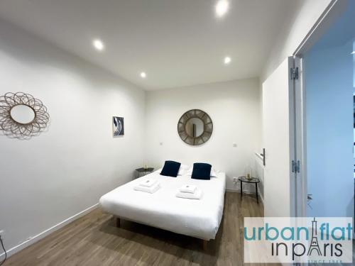- une chambre blanche avec un lit blanc et des oreillers bleus dans l'établissement Urban Flat 187 - Sublime 1 Bedroom in Paris, à Paris
