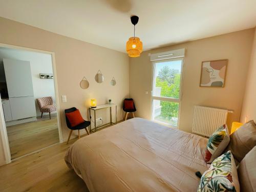 une chambre avec un grand lit et une fenêtre dans l'établissement T2 neuf quartier Vieux Port avec ascenseur et terrasse, à La Rochelle