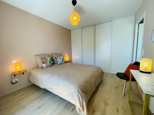 Cette chambre comprend un lit avec deux lampes et un bureau. dans l'établissement T2 neuf quartier Vieux Port avec ascenseur et terrasse, à La Rochelle