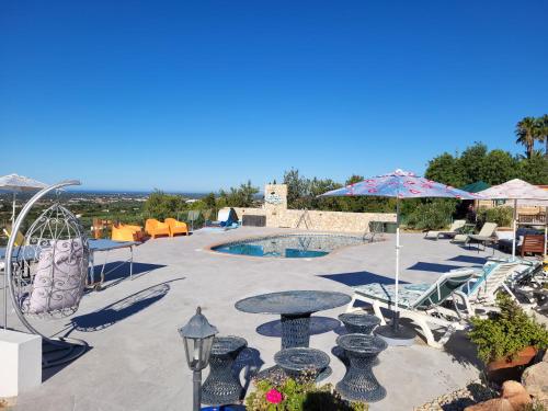 a patio with a table and chairs and a pool at Vista Magica B&B in Santa Bárbara de Nexe