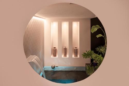 een badkamer met een ronde spiegel met een bad bij Palazzo Biancofiore, suites & rooftop Ostuni in Ostuni